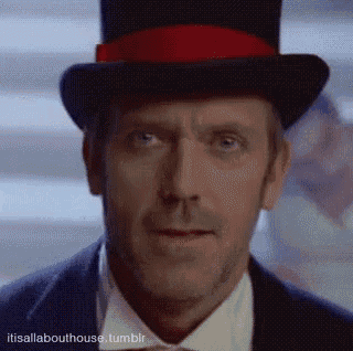 a man wearing a top hat with a red ribbon looks at the camera .
