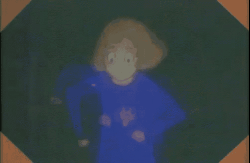 a cartoon girl in a blue shirt is standing in the dark .