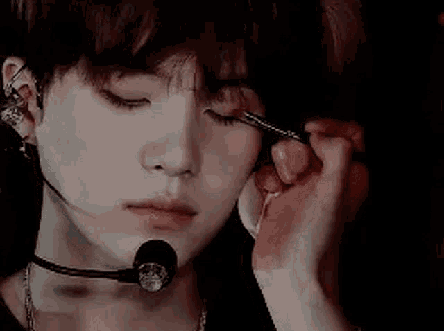 a close up of a person applying makeup to another person 's eye .