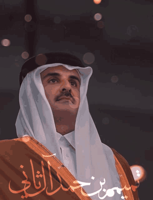 a man in a traditional costume with arabic writing on it