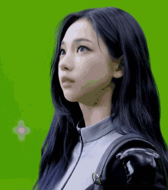 a woman with long black hair and a black backpack looks to the side