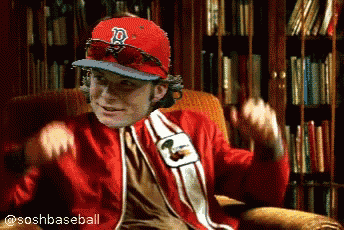 a man wearing a red sox hat and sunglasses