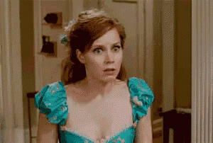 a woman in a blue dress is standing in front of a mirror .
