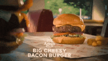 an arby 's big cheesy bacon burger is on a table