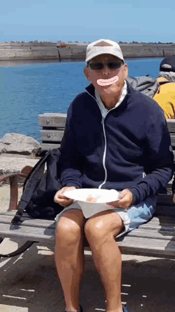 a man sitting on a bench with a plate of food