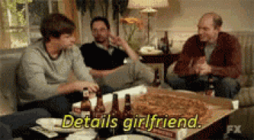 a group of men are sitting around a table with a box of pizza and the words details girlfriend written on it