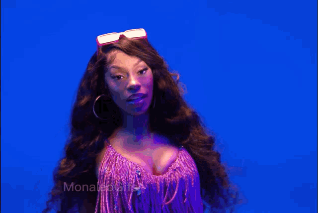 a woman wearing a purple top and hoop earrings stands in front of a blue background with the word morales on it