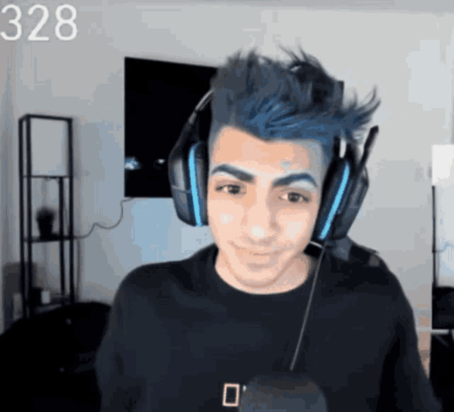 a man with blue hair is wearing headphones and the number 328 is behind him