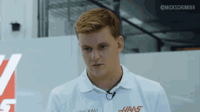 a man wearing a white shirt that says hinas
