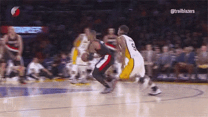 a group of basketball players are playing a game of basketball on a court in front of a crowd .
