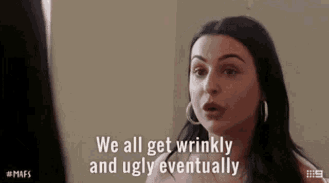 a woman is looking at herself in a mirror and saying `` we all get wrinkled and ugly eventually '' .