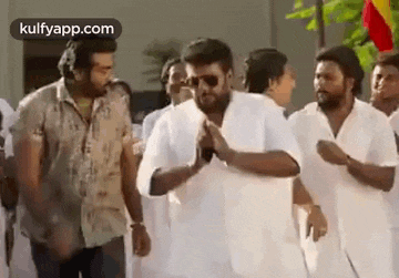 a group of men in white shirts are standing next to each other .