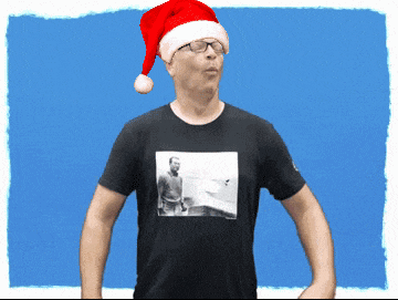 a man wearing a santa hat and glasses has a picture of a man on his shirt
