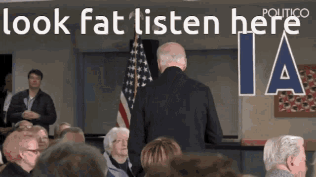 a man stands in front of a crowd with the words look fat listen here