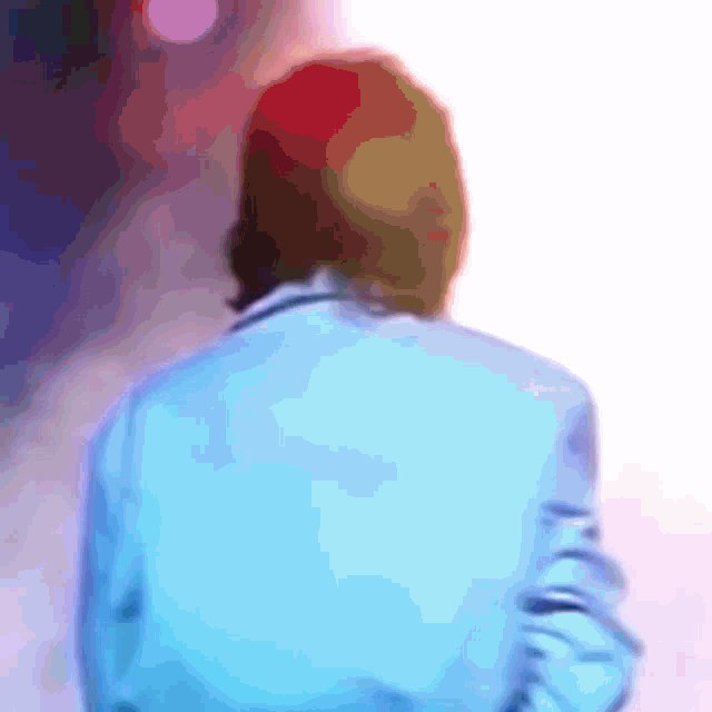 a blurry picture of a person wearing a blue jacket
