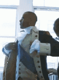 a man in a suit is being helped by another man .