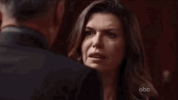 a man and a woman are hugging each other in a dark room .