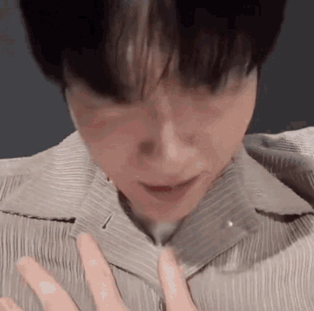 a close up of a person 's face and chest with their hands on their chest .