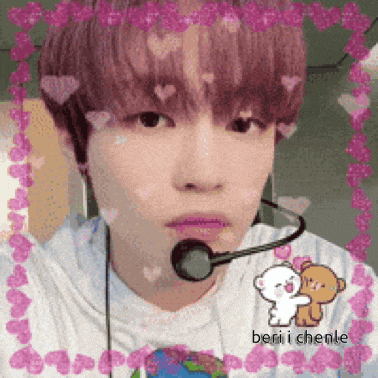 a young man wearing a microphone and headphones is taking a selfie .