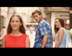 a man in a blue plaid shirt is walking down a street with two women behind him