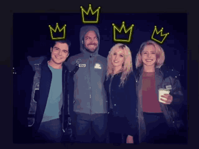 a group of people are posing for a picture with neon crowns above them