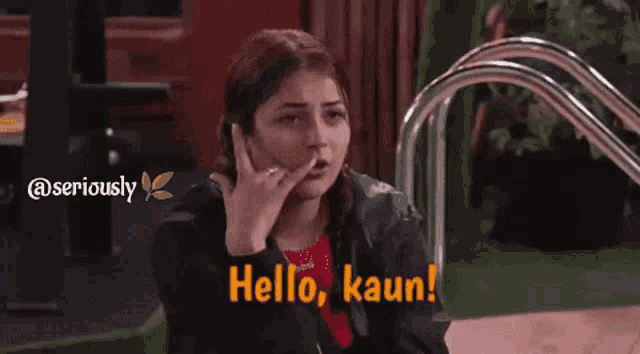 a woman is making a phone call with her hand and the words hello kaun on the bottom