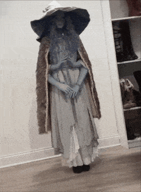 a woman in a witch costume is standing in a closet