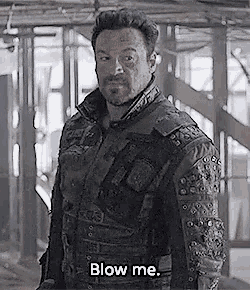 a man in a leather jacket says blow me while standing in a building