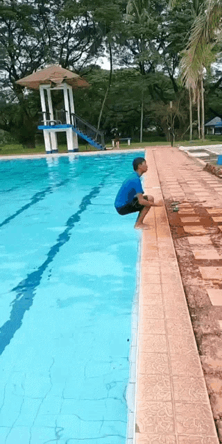 a man squats on the edge of a pool