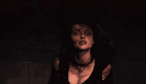 a woman with a very large breast is standing in a dark room with her eyes wide open .