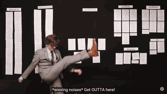 a man in a suit is kicking in front of a board that says snoring noises