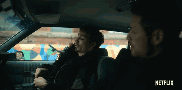 two men in a car with a netflix logo on the bottom