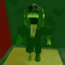 a green monster with a huge mouth is standing on a table .