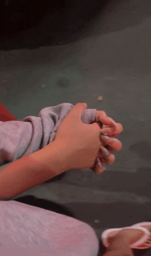 a person is holding another person 's hand with their fingers crossed