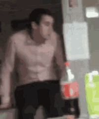 a man without a shirt is holding a bottle of coca cola