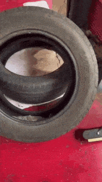 two tires are stacked on top of each other on a red surface and one has the word eagle on it