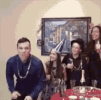 a group of people are sitting at a table with a bottle of champagne .