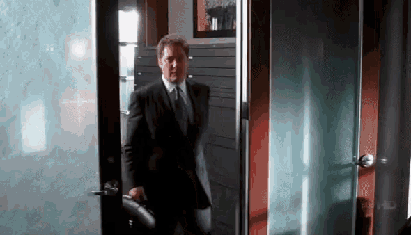 a man in a suit and tie is walking through a door that says abc hd on the door