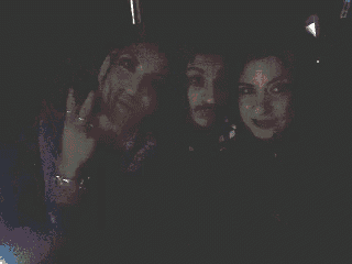 three people are posing for a photo in the dark