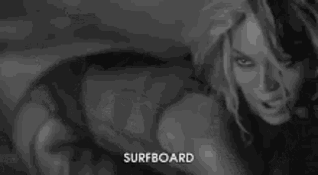 a black and white photo of two women standing next to each other with the word surfboard written in the corner .