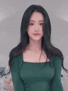 the woman is wearing a green sweater and a necklace .