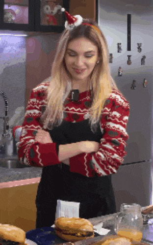 a woman with a santa hat on her head is standing in a kitchen