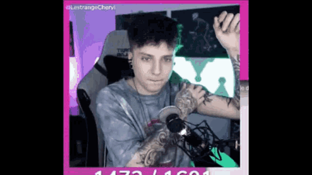 a man with a tattoo on his arm is sitting in front of a microphone