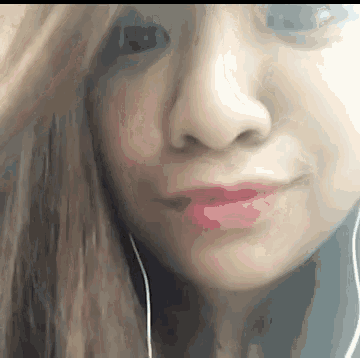 a close up of a woman 's face with red lipstick and ear buds