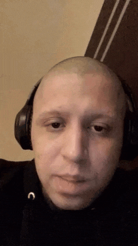 a man with a shaved head wearing headphones