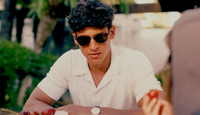 a man wearing sunglasses sits at a table