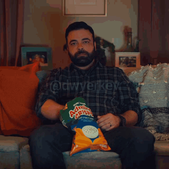 homem sozinho em casa comendo chips enquanto assiste Netflix