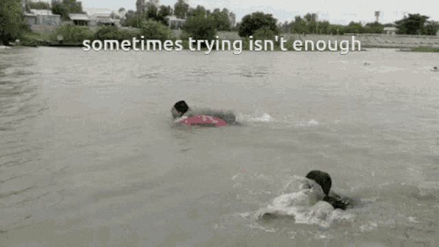 a person is swimming in a body of water with the words " sometimes trying isn 't enough " below them