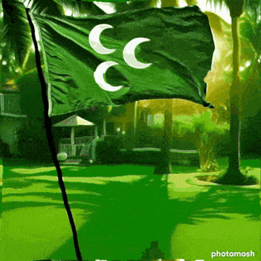 a green flag with three white crescent moons flying in the wind