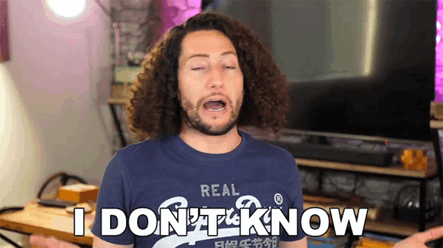 a man with curly hair wearing a blue shirt that says i don 't know